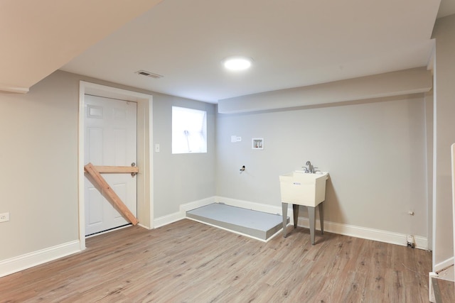 clothes washing area featuring washer hookup and light wood-type flooring