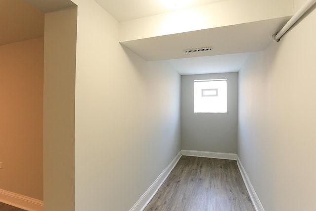 hallway with hardwood / wood-style floors