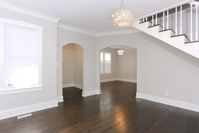 interior space with dark hardwood / wood-style flooring, crown molding, and an inviting chandelier