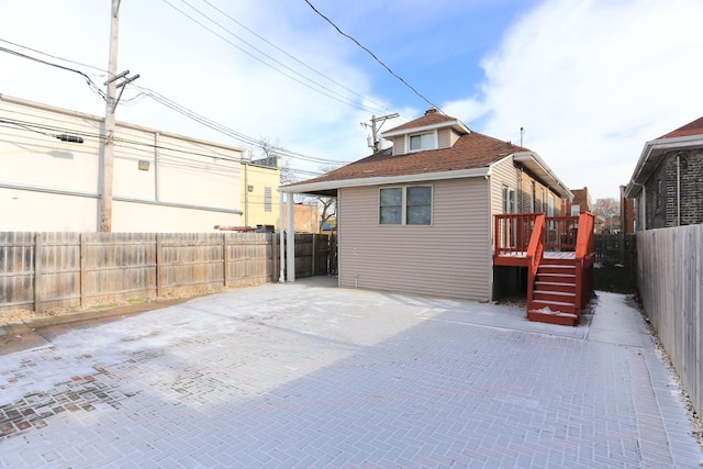 rear view of property featuring a wooden deck