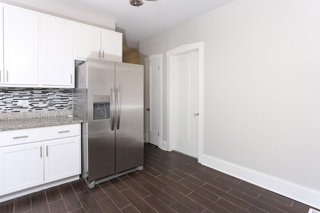 kitchen featuring white cabinetry, stainless steel fridge with ice dispenser, tasteful backsplash, and light stone countertops