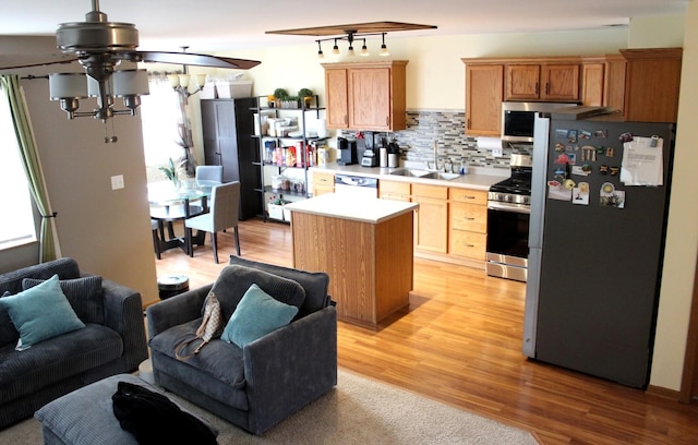 kitchen with sink, decorative backsplash, appliances with stainless steel finishes, plenty of natural light, and light hardwood / wood-style floors