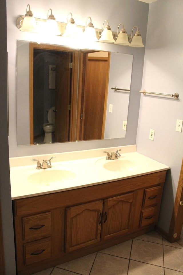 bathroom featuring tile patterned flooring, vanity, and toilet