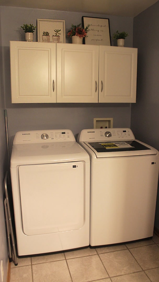 laundry room with separate washer and dryer, light tile patterned floors, and cabinets