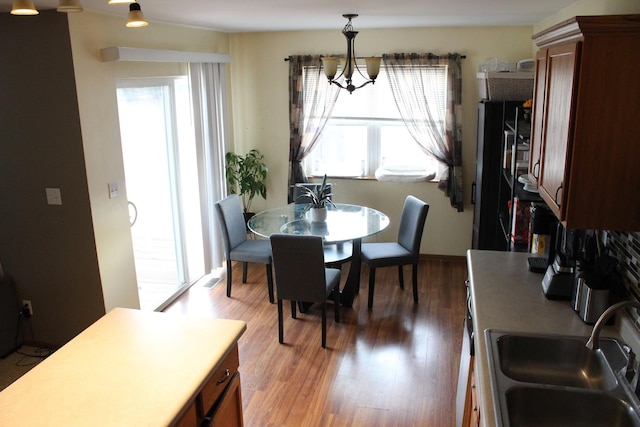 dining area with hardwood / wood-style flooring, sink, and a chandelier