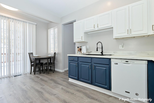 kitchen featuring dishwasher, light wood-type flooring, white cabinets, and sink