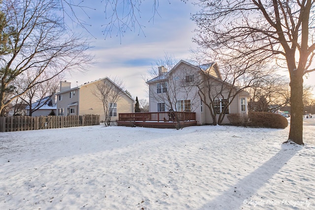 snow covered rear of property featuring a deck