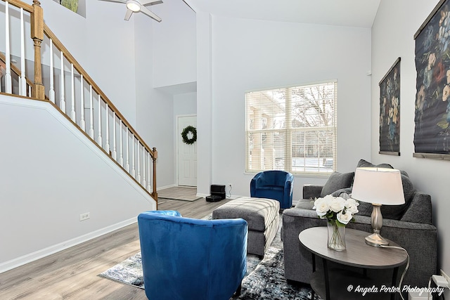 living room with ceiling fan, high vaulted ceiling, and light hardwood / wood-style floors