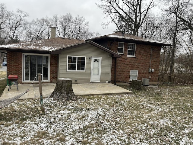 snow covered property featuring cooling unit and a patio