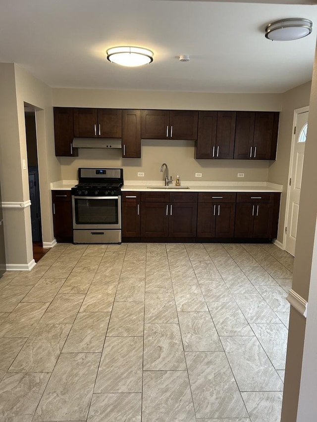 kitchen with dark brown cabinets, gas stove, and sink