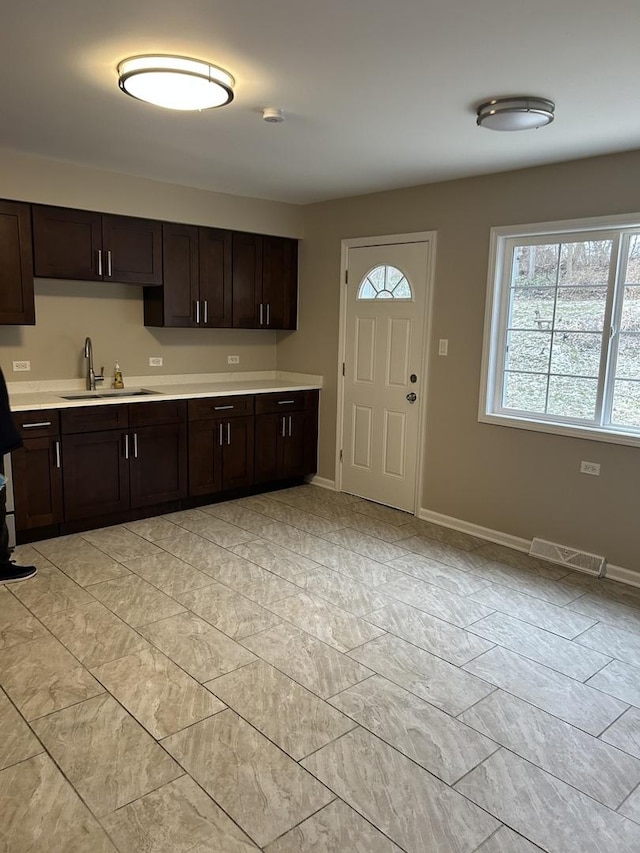 kitchen featuring dark brown cabinets and sink