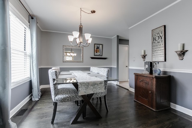 dining space featuring a healthy amount of sunlight, ornamental molding, and an inviting chandelier