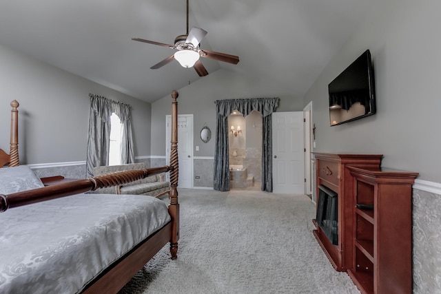 carpeted bedroom featuring ceiling fan, ensuite bath, and vaulted ceiling