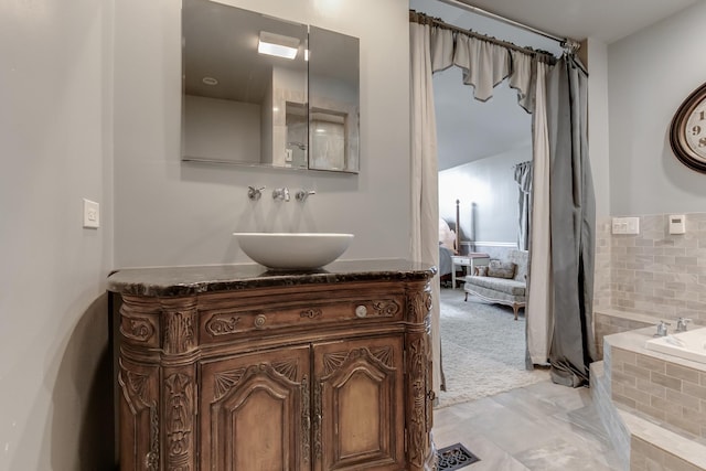 bathroom with tiled tub and vanity