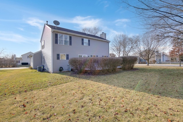 rear view of property with a yard and central AC unit