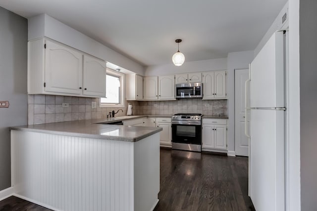 kitchen with white cabinetry, decorative light fixtures, and appliances with stainless steel finishes