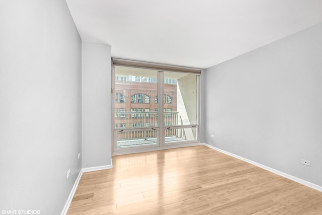 unfurnished room featuring expansive windows and light wood-type flooring