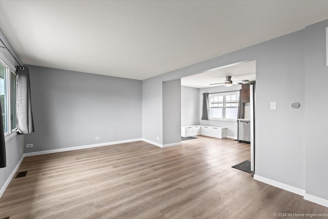 empty room with ceiling fan and light hardwood / wood-style flooring