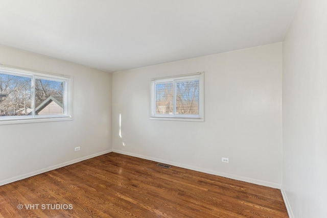 unfurnished room with dark hardwood / wood-style flooring