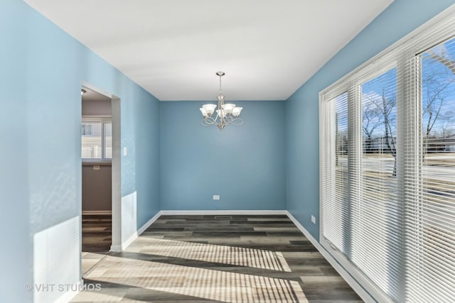 unfurnished dining area featuring hardwood / wood-style floors, plenty of natural light, and a chandelier