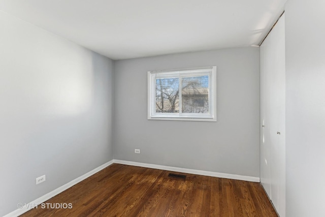 empty room with dark hardwood / wood-style floors