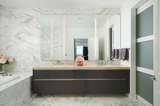 bathroom with a bath, a sink, and double vanity