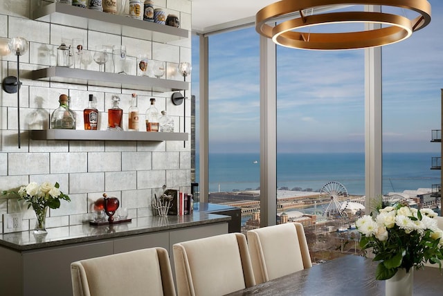 bar with backsplash and a water view