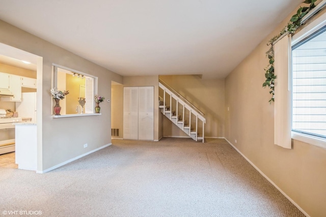 unfurnished living room with light colored carpet