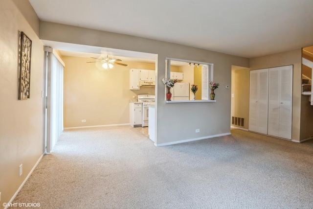 unfurnished living room featuring light colored carpet and ceiling fan