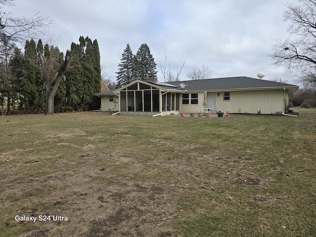 rear view of property with a sunroom and a yard