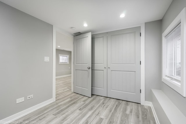 unfurnished bedroom with a closet and light hardwood / wood-style flooring