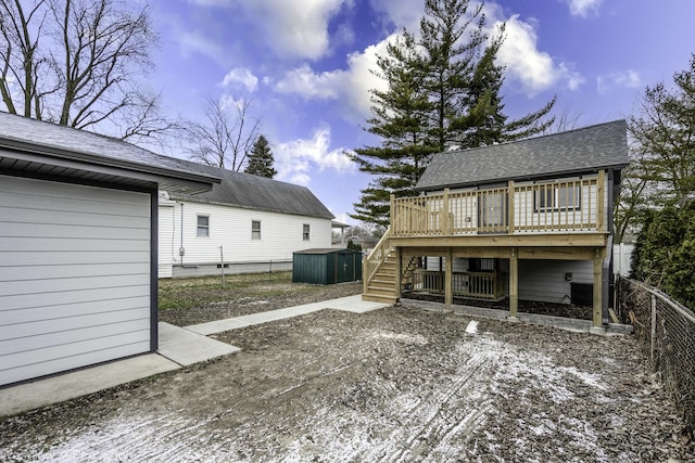 back of house featuring a deck and an outbuilding