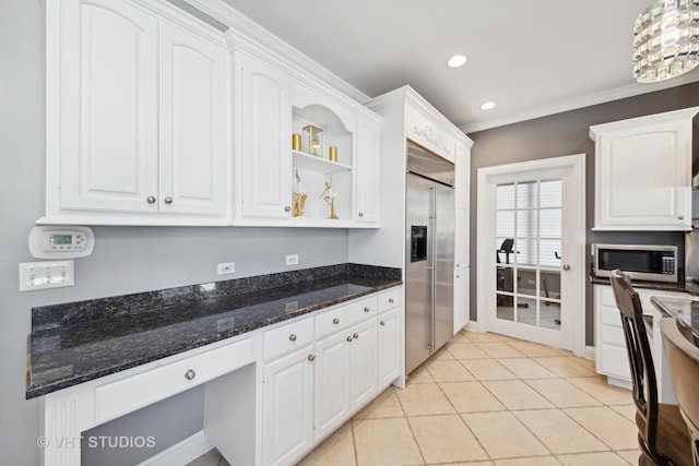 kitchen with light tile patterned floors, white cabinetry, dark stone countertops, stainless steel appliances, and ornamental molding