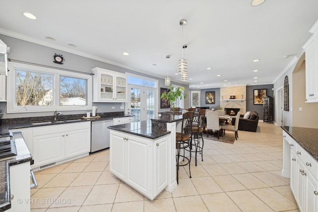 kitchen with a kitchen island, decorative light fixtures, sink, white cabinets, and stainless steel dishwasher