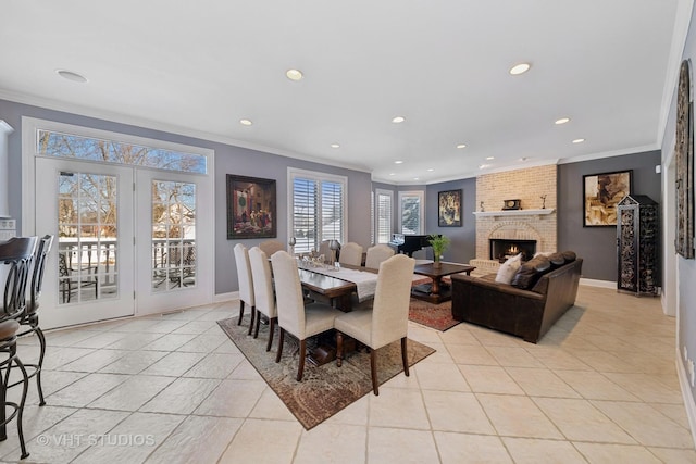 dining space with light tile patterned floors, crown molding, and a brick fireplace