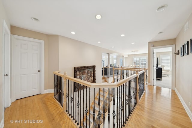 corridor with an inviting chandelier and hardwood / wood-style floors