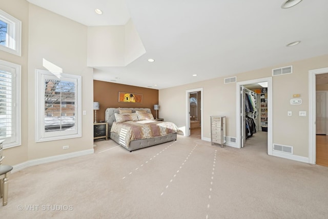 carpeted bedroom featuring a walk in closet and a closet