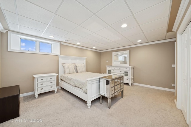 carpeted bedroom with crown molding and a paneled ceiling