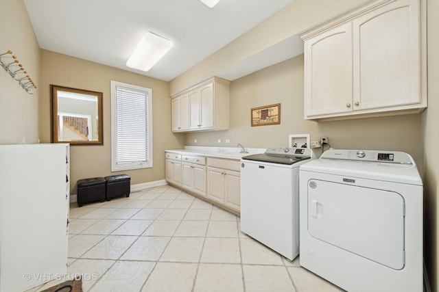 laundry room featuring independent washer and dryer, cabinets, sink, and light tile patterned floors