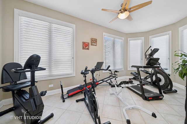 exercise area with light tile patterned flooring and ceiling fan