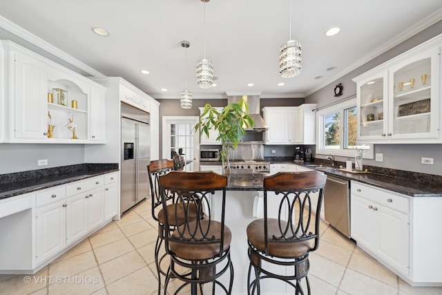 kitchen featuring white cabinetry, a center island, dark stone counters, pendant lighting, and stainless steel appliances