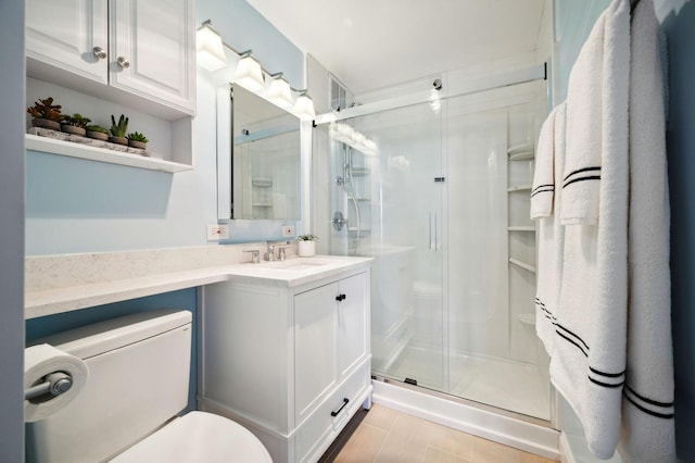 bathroom featuring tile patterned flooring, vanity, toilet, and a shower with shower door