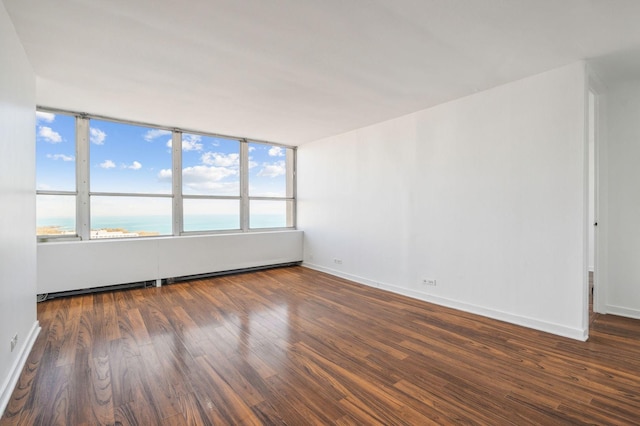 spare room featuring dark hardwood / wood-style floors and a water view