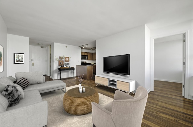 living room featuring rail lighting and dark wood-type flooring