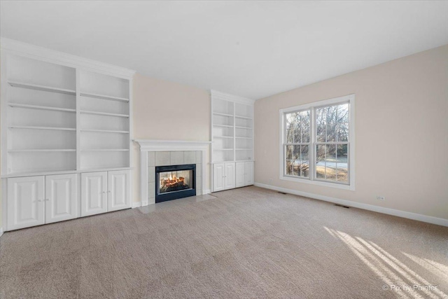 unfurnished living room featuring carpet flooring, built in features, and a fireplace