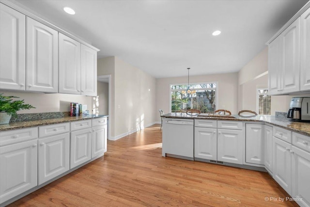 kitchen with white cabinetry, dishwasher, a chandelier, pendant lighting, and stone countertops