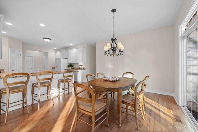 dining area featuring a notable chandelier and light hardwood / wood-style floors