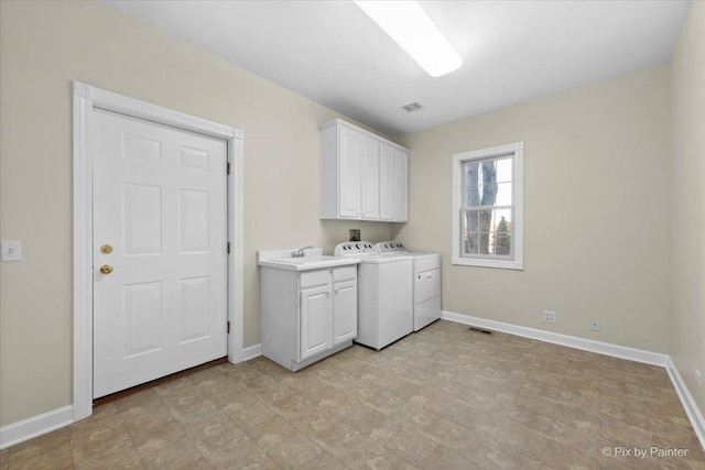 laundry area with washing machine and dryer, sink, and cabinets