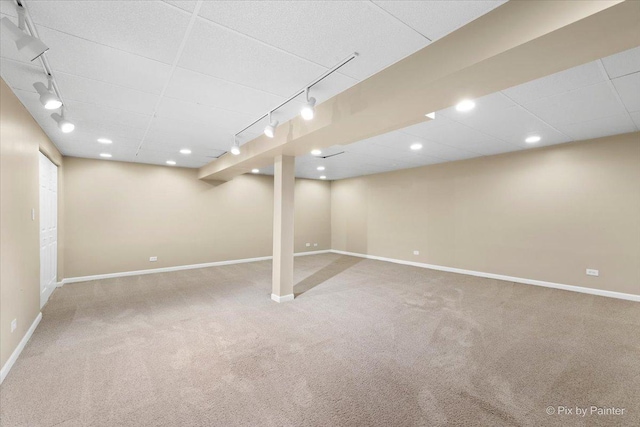 basement featuring carpet flooring and track lighting