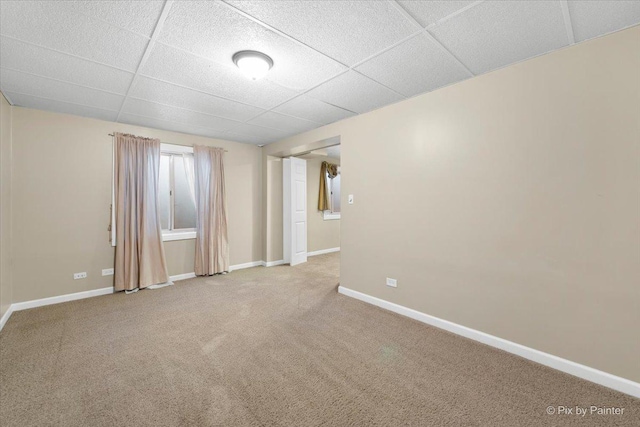 carpeted empty room with a drop ceiling